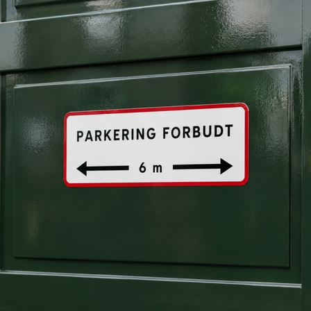 Blank vinyldekal med teksten “PARKERING FORBUDT” og 6 m afstandsmarkering, monteret på en mørkegrøn, blanklakeret port.