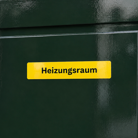 Glänzender gelber Vinylaufkleber mit der Aufschrift „Heizungsraum“, angebracht auf einem dunkelgrünen, hochglanzlackierten Tor.